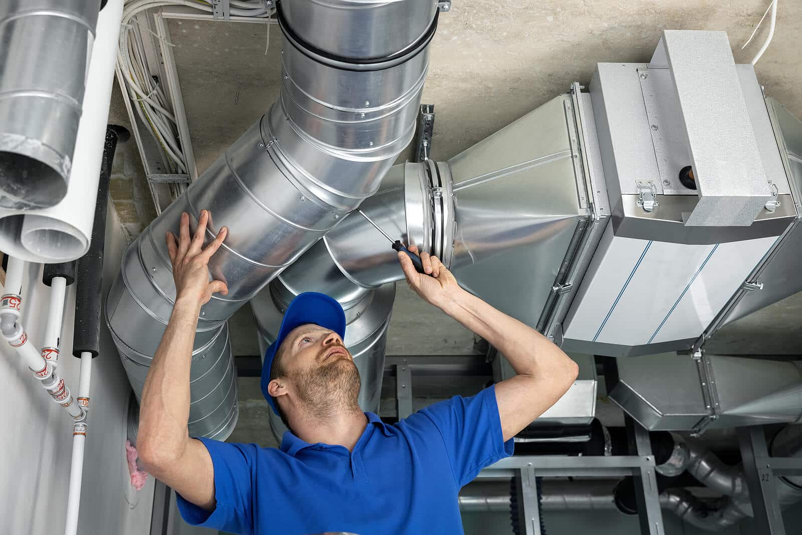 HVAC technician inspecting and repairing air ducts in Reedley