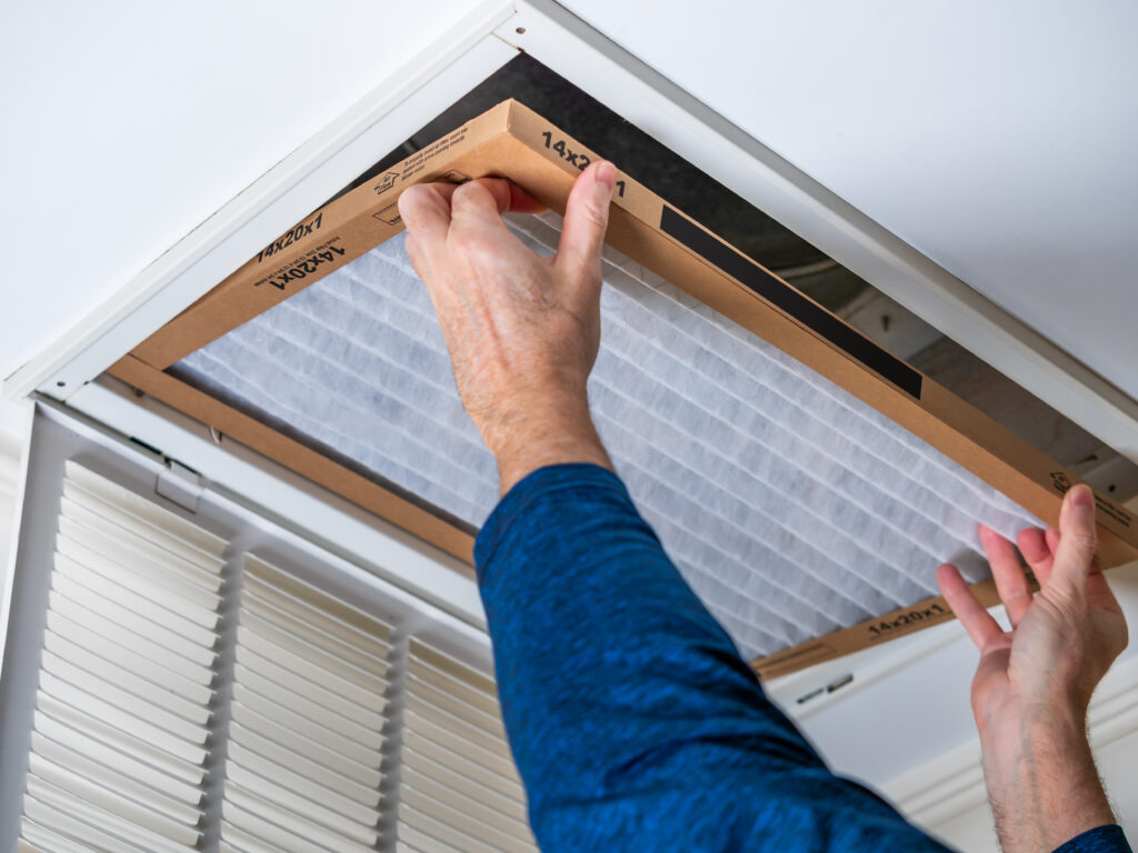 HVAC technician replacing a home air filter in Reedley