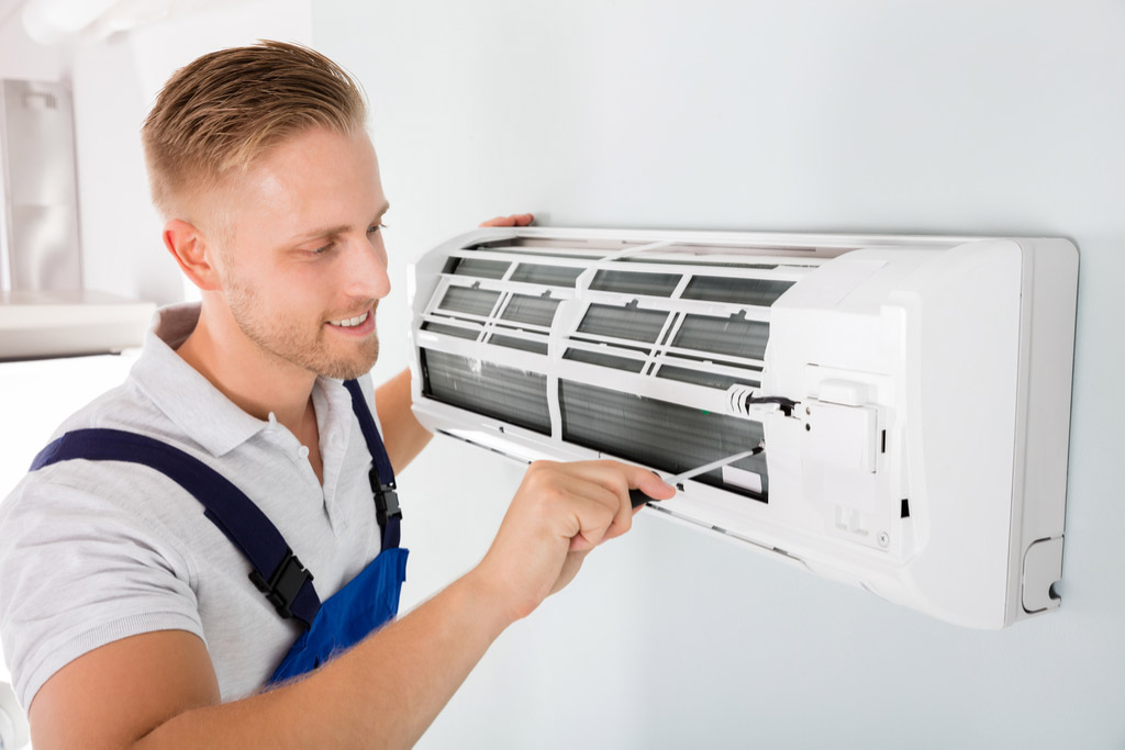 HVAC technician maintaining a ductless air conditioner in Reedley
