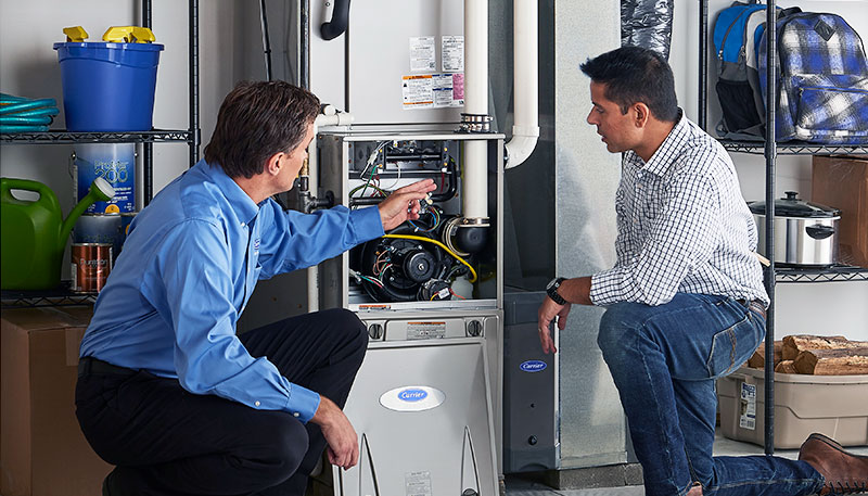 Technician evaluating a furnace for repair or replacement in Reedley