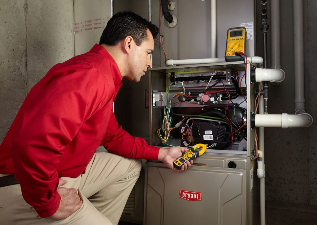 Heating technician diagnosing a furnace repair in Reedley
